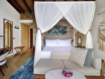 Schlafzimmer mit Himmelbett, Sofa, Tisch und einer blauen Teppichmatte in modernem Stil.