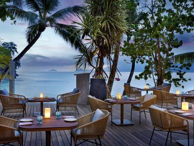 Gemütliche Außenrestaurant-Terrasse mit Kerzen und Meerblick bei Sonnenuntergang