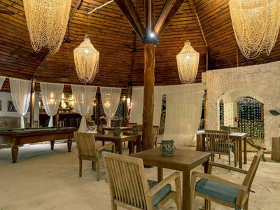 Gemütlicher Hotel-Loungebereich mit Holzmöbeln und stilvollen Lampen unter einer Holzbalkendecke.