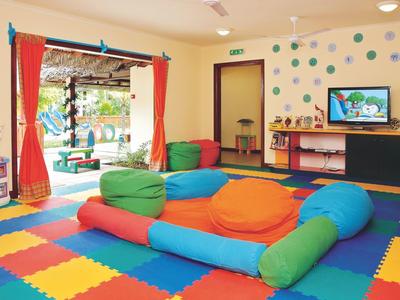 Sala de juegos colorida para niños con cojines y vista al exterior.