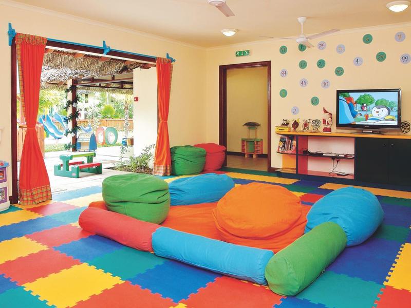 Sala de juegos colorida para niños con cojines y vista al exterior.