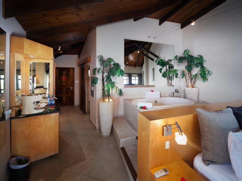 Espace chambre d'hôtel confortable avec plafond en bois, plantes et sièges confortables.