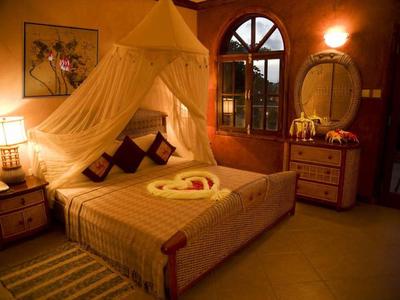 Gemütliches Schlafzimmer mit Holzmöbeln, Himmelbett, warmem Licht und dekorativem Netz.