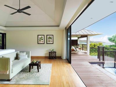 Habitación de hotel moderna con balcón abierto y vista a la piscina y plantas tropicales.