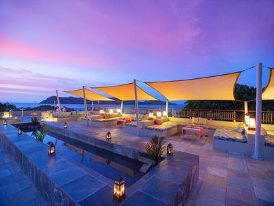Rooftop terrace with comfortable seating, lit up at sunset.
