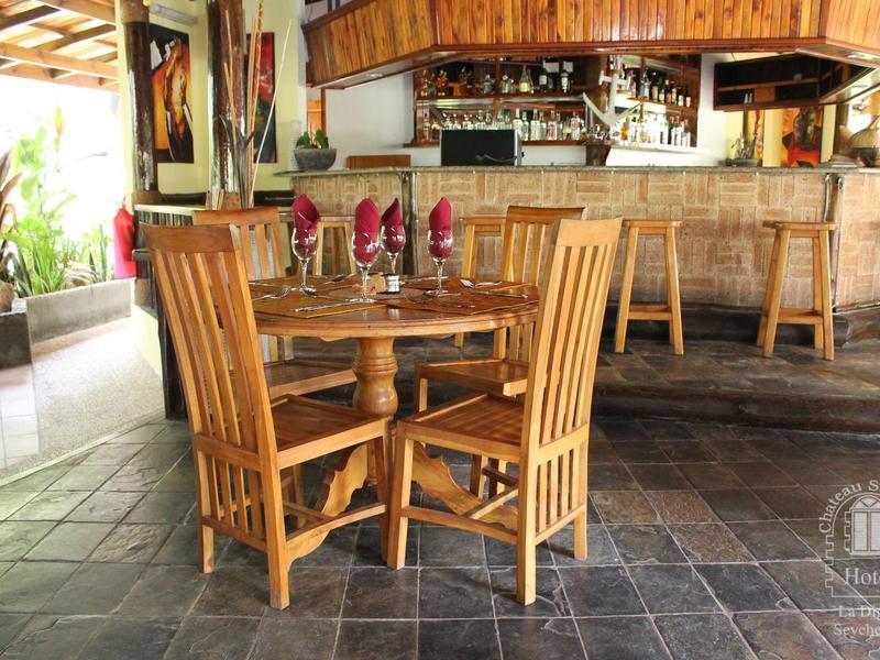 Drewniany stół z czterema krzesłami i nakrytym stołem w rustykalnym barze z ladą.