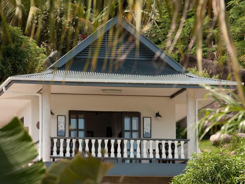 Balkon domu z białymi balustradami i wieloma zielonymi roślinami na pierwszym planie