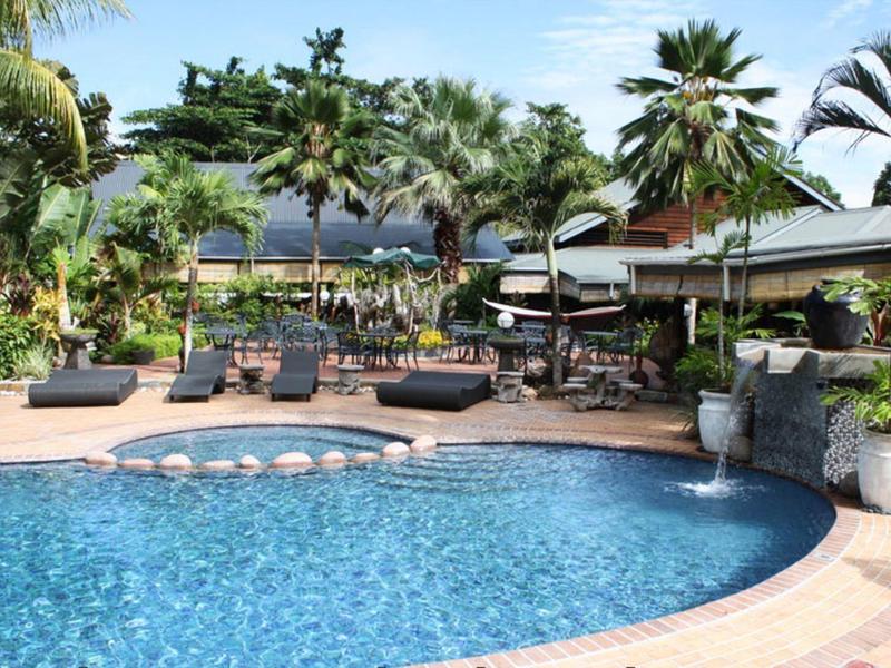 Relaksująca strefa basenowa z leżakami i tropikalnymi palmami w hotelu.