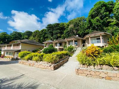 Hotelgebäude in einer grünen, bewaldeten Umgebung bei blauem Himmel.