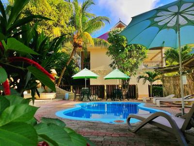 Area piscina con lettini e ombrelloni in hotel tropicale