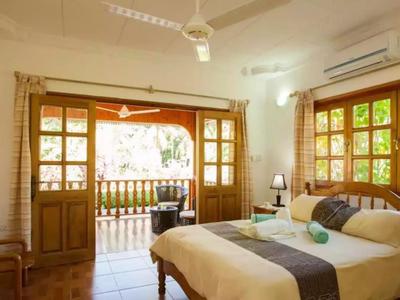 Brightly furnished bedroom with double bed and open access to the balcony.