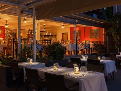 Elegantes Hotelrestaurant mit gedeckten Tischen und stimmungsvoller Beleuchtung am Abend.
