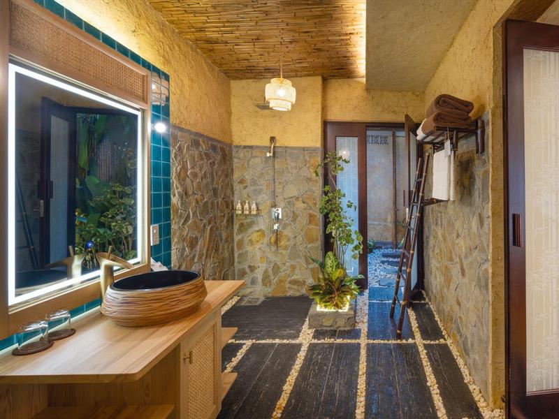 Vstupní prostor s dřevěným nábytkem, osvětleným zrcadlem a dekorativními rostlinami.