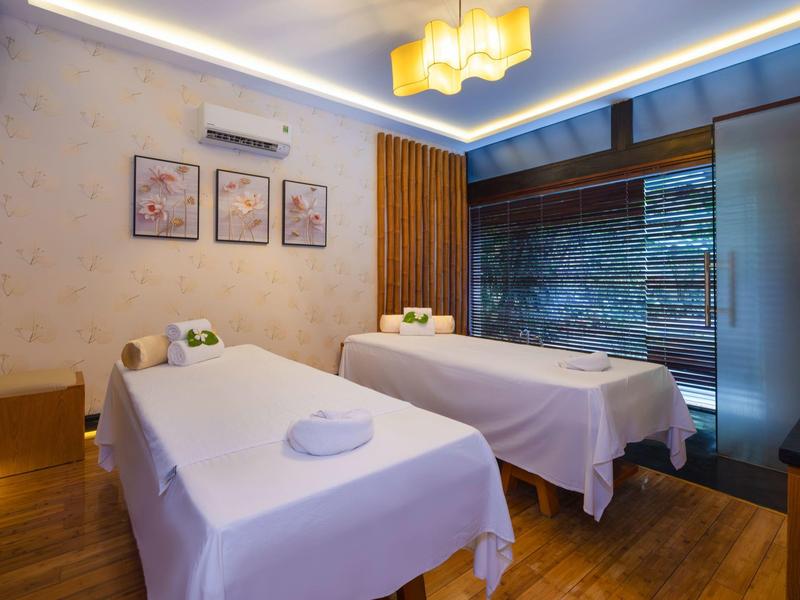 Moderní wellness masážní místnost se dvěma lůžky a atmosférickým osvětlením.