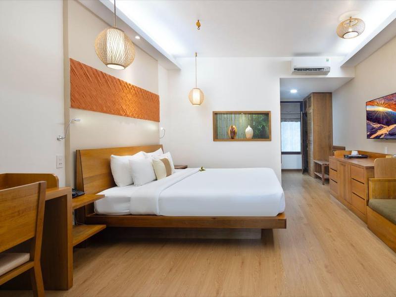 Moderně zařízený hotelový pokoj se dvěma lůžky, TV a dřevěným nábytkem.