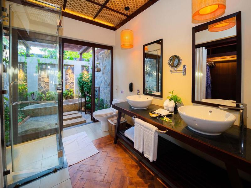 Moderne badkamer met dubbele wastafels en toegang tot een privé tuin.