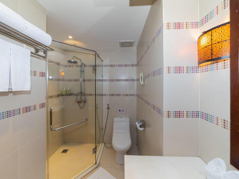 Moderne badkamer met glazen douche, toilet en handdoekrek aan de muur.