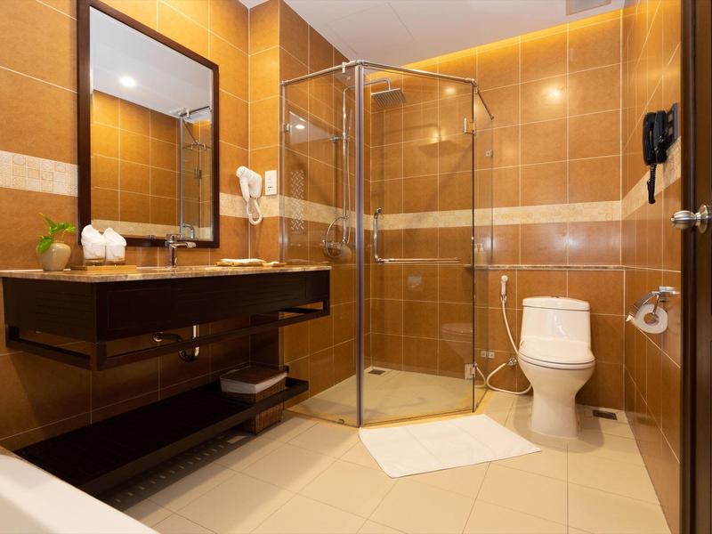 Moderne badkamer met glazen douche, toilet, wastafel en grote spiegel.