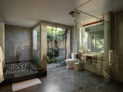 Nowoczesna łazienka z dużym prysznicem, wolnostojącą wanną i oknami od podłogi do sufitu z widokiem na ogród
