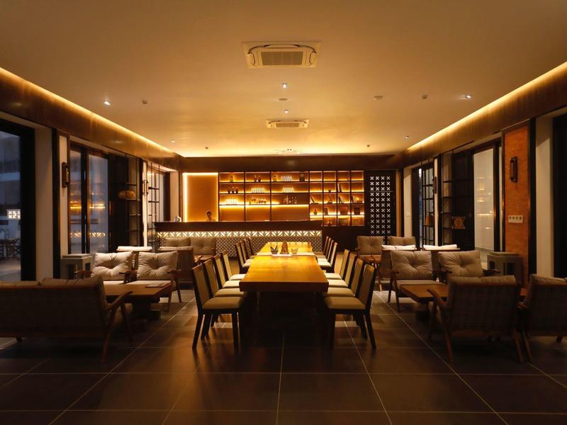 Nowoczesny bar hotelowy z przytulnym oświetleniem i miejscami do siedzenia.