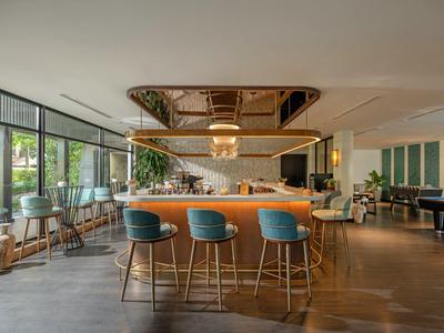 Nowoczesny bar hotelowy ze stylowymi miejscami do siedzenia i dużymi oknami.