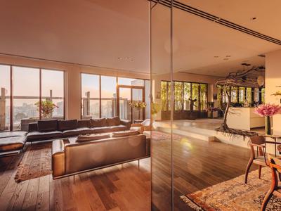 Großer, heller Hotellobby-Bereich mit Glaswänden, Holzboden und modernem Mobiliar