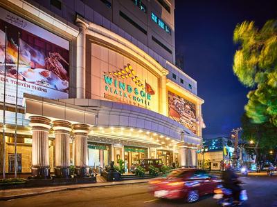 Helles Einkaufszentrum mit großen Säulen, bunten Lichtern und Verkehr bei Nacht.