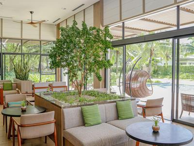 Helles, modernes Lounge mit bequemen Sitzmöbeln und Blick auf den Pool und Garten.