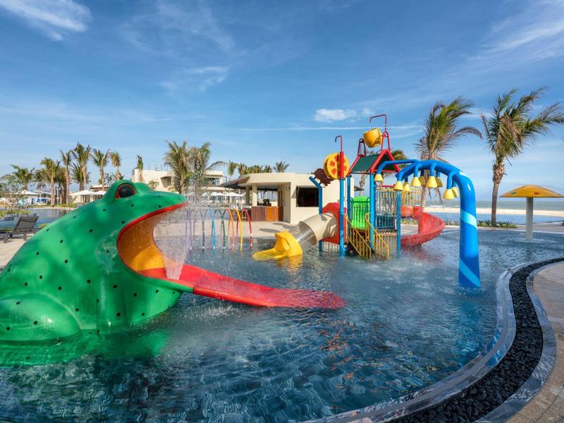 Barevné vodní hřiště se skluzavkami a tematickými prvky v venkovním bazénu.