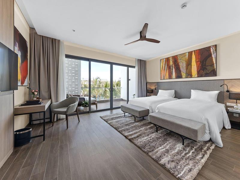 Nowoczesny pokój hotelowy z dużym łóżkiem, balkonem i współczesną sztuką na ścianie.