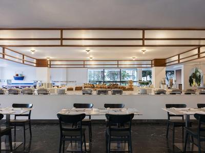 Grande salle à manger moderne avec tables et chaises dans un hôtel.