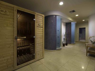 Espace bien-être moderne avec sauna et banc dans une pièce lumineuse.