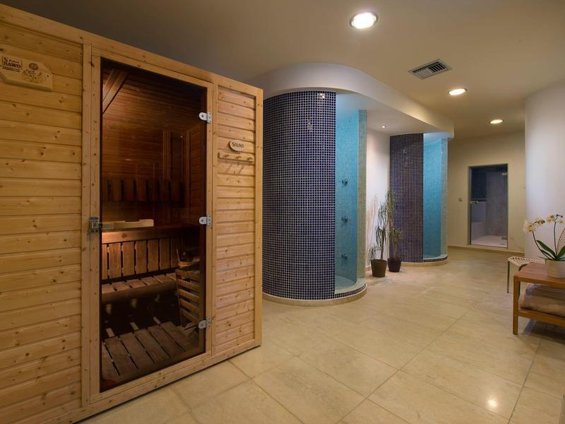 Área de bienestar moderna con sauna y baños de vapor redondos en una habitación iluminada.