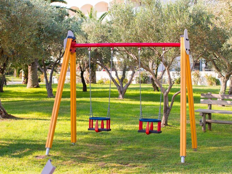 Estructura de columpio con dos columpios en un parque al aire libre con césped