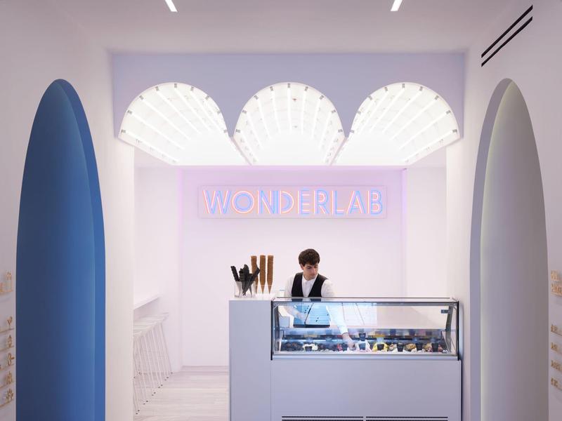 Recepción moderna con arcos azules y mostrador claro en un hotel.