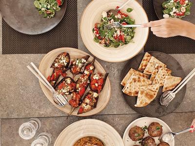 Disposición de comida vista desde arriba con ensalada, tostadas, albóndigas y tomates secos.