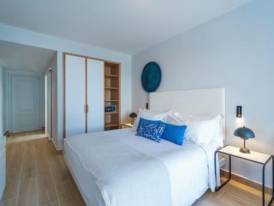 Modern bedroom with double bed, nightstand, and built-in wardrobe.