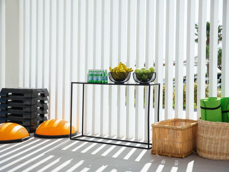 Outdoor space with baskets, orange exercise discs, and a small table with fruit bowls.