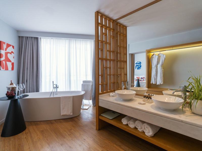 Modern bathroom with freestanding bathtub and separate wash area in a bright design.