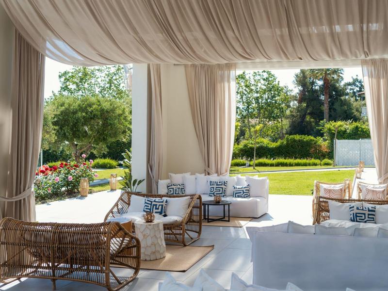 Elegant lounge with comfortable seating and a view of a lush garden.