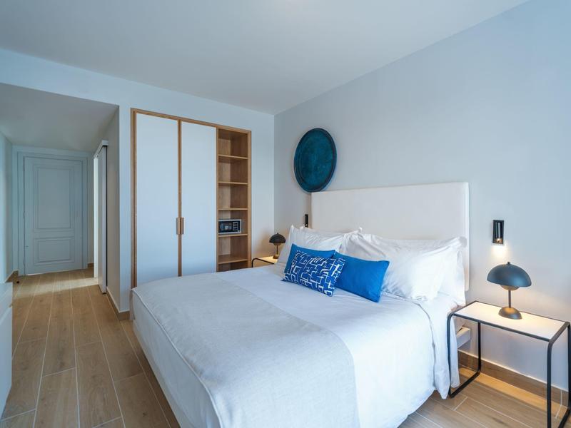 Modern bedroom with double bed, nightstand, and built-in wardrobe.