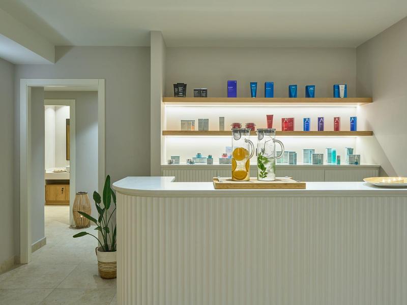 Modern reception area with counter, shelves, and contemporary lighting.