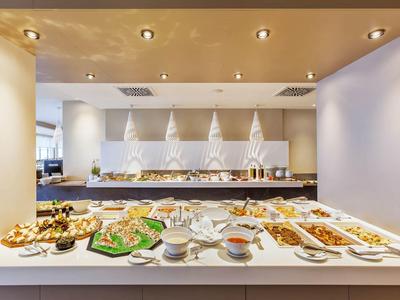 Buffet with diverse dishes and drinks in a modern, well-lit restaurant setting.