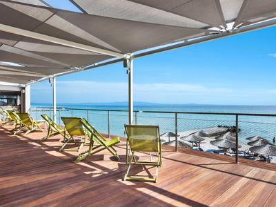 Terrasse mit Liegestühlen und Blick auf das Meer bei sonnigem Wetter