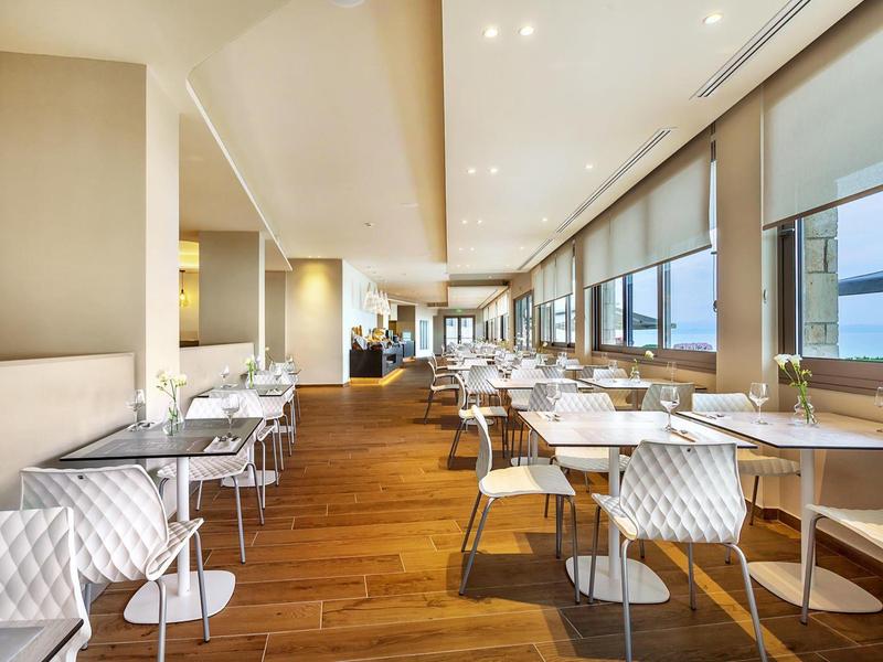 Modern dining room with large windows and wooden floor offering sea views.