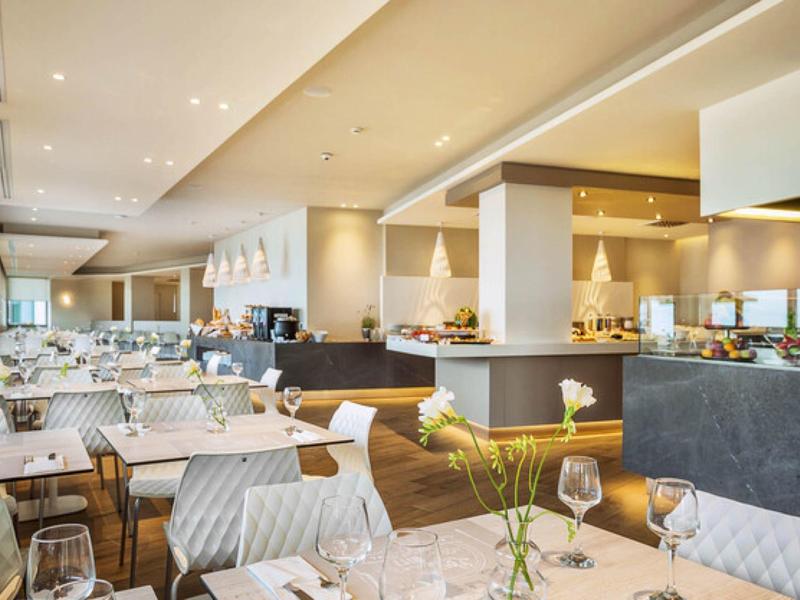Modern hotel restaurant with set tables and stylish lighting.