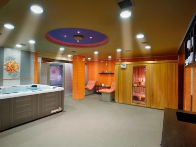 Moderne Wellness-Landschaft mit Whirlpool, Holzverkleidung und warmen Lichtakzenten.