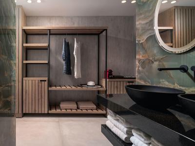 Moderner begehbarer Kleiderschrank mit offenem Holzmöbel und schwarzem Waschbecken im Stilbad.
