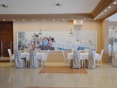 Innenansicht eines eleganten Restaurants mit runden Tischen und weiß gedeckten Stühlen.