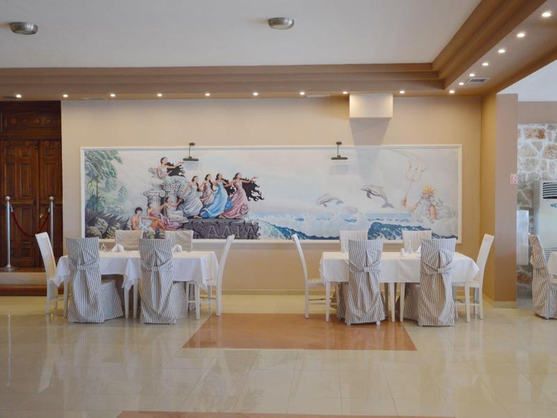 Moderner Veranstaltungsraum mit dekorierten Tischen und großem Wandbild in hellem Ambiente.